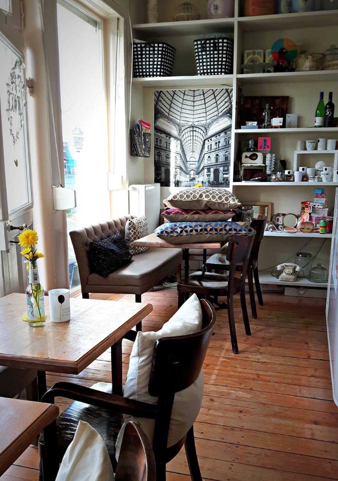 caferoom with pillows on a table and a shelf full of living accessories 