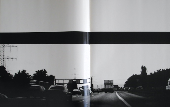 black and white photo of a highway with a vanishing point on the horizon 