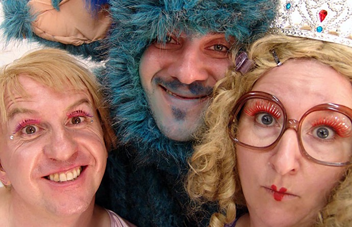 three grinning faces: a female fairy, a male fairy and a blue made up monster 